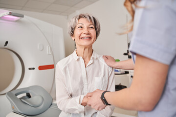 Happy senior patient lady visiting MRI procedure in hospital