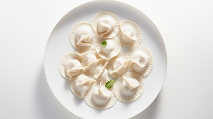 Fototapeta na wymiar a plate of dumplings with a green leaf on top of it on a white tablecloth with a white background.