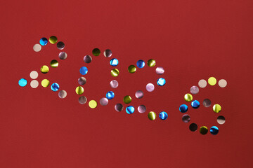 Happy new year 2026 red background. Round multicolored sequins. Minimalistic Christmas greeting card.