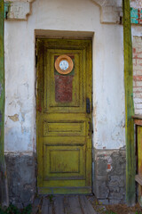 Old shabby green doors with a round icon of St. Nicholas the Wonderworker