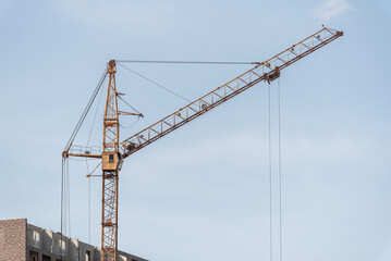 A construction site with a tower crane erecting a new house.