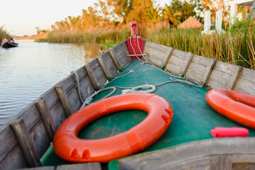 A traditional Valencian boat in the lagoon, with life buoys.