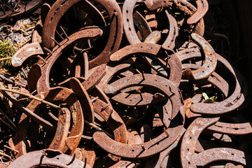 Pile of old abandoned rusty horseshoes.