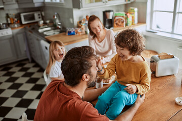 Cheerful family has fun during a meal at the dining table