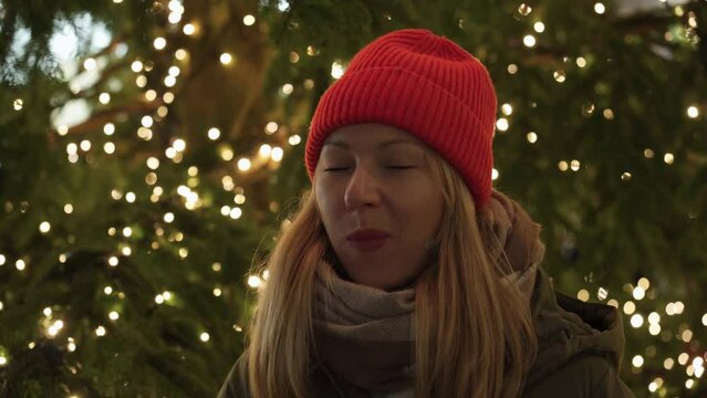 Girl eating a tangerine near the Christmas tree