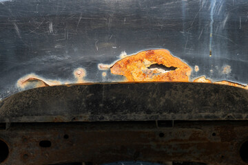 A rusty black car fender