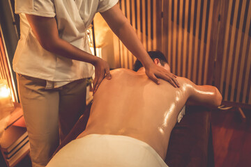 Rear view man customer enjoying relaxing anti-stress spa massage and pampering with beauty skin...
