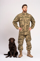 Full length handsome bearded man, soldier training brown Labrador dog looking away isolated on white background