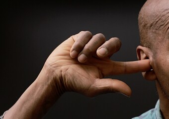 deaf man suffering from deafness and hearing loss on grey background with people stock photo	