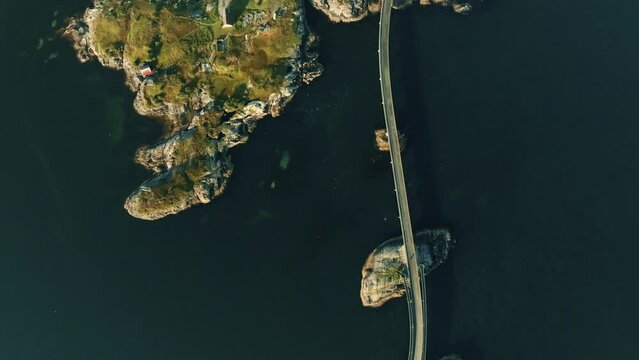 Epic highway located on small green stony islands in the middle of vast sea on Lofoten islands. Top-down drone view.