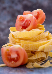 Isolated tagliatelle pasta with sliced tomatoes close-up