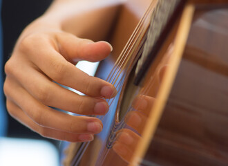 Female human hand playing an accoustic guitar  strumming the strings