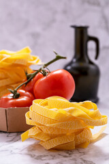 Ingredients for preparing pasta, tagliatelle and tomato bunches