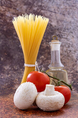 Spaghetti pasta, red mushrooms and bottle of oil close-up