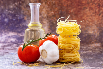 Homemade red garlic pasta and bottle of oil close-up