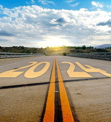 Año nuevo 2024 o concepto de inicio.. Palabra 2024 escrita en la carretera asfaltada con líneas amarillas. Concepto de desafío y cambio.