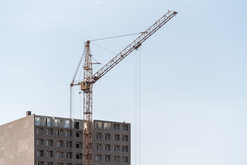 Fototapeta na wymiar A construction site with a tower crane erecting a new house.