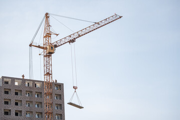 A construction site with a tower crane erecting a new house.