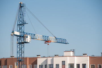 A construction site with a tower crane erecting a new house.