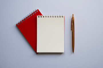 Top view on a red notepad and golden pen