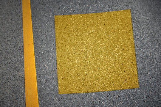 yellow map of colorado state on asphalt road near yellow line.