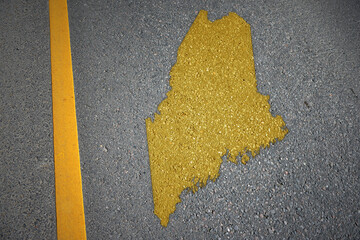 yellow map of maine state on asphalt road near yellow line.