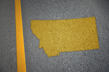 yellow map of montana state on asphalt road near yellow line.