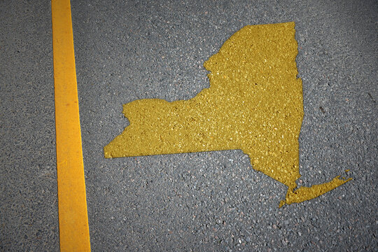 yellow map of new york state on asphalt road near yellow line.