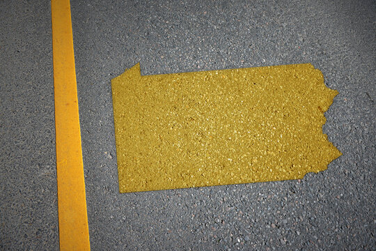 yellow map of pennsylvania state on asphalt road near yellow line.