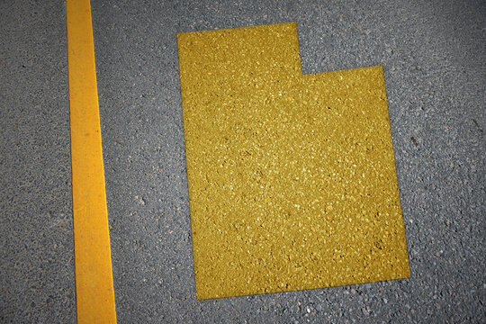 yellow map of utah state on asphalt road near yellow line.