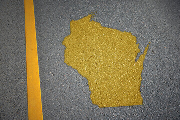 yellow map of wisconsin state on asphalt road near yellow line.