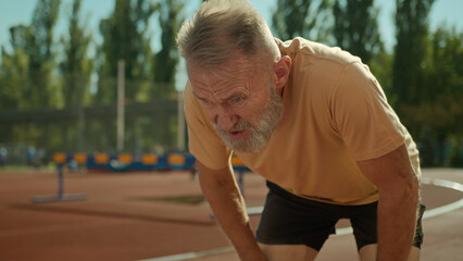 Caucasian exhausted elderly man runner tired jogging sport activity healthy lifestyle stadium...