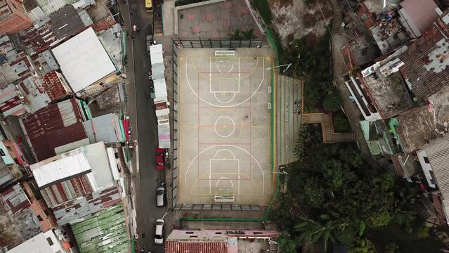 Aerial drone footage of Comuna 13 slum and basketball field, favela in Medellin, Colombia, Latin America. Most dangerous neighborhood in the world. High quality 4k footage.