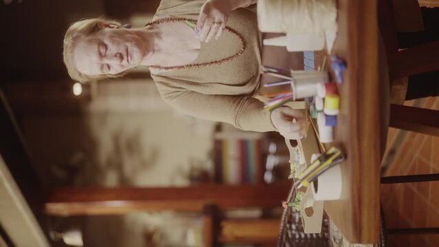 Artista senior, concentrada pintando um vaso de ceramica. Cinematico 4k. Video vertical.
