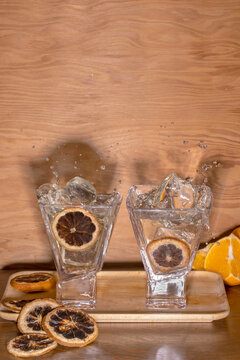 2 cocktails with splashes on wood