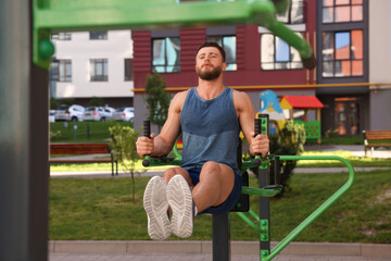 Man doing leg rise exercise at outdoor gym