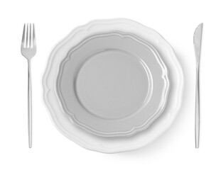 Clean plates, fork and knife on white background, top view