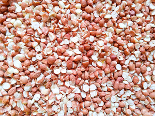 close up of pile of peanuts. peanut pieces. food background. dry peanuts