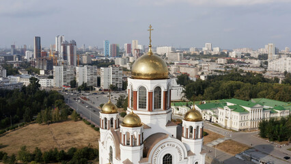 Obraz premium Orthodox white church building with golden domes outdoors. tock footage. Christianity religion, cathedral or temple with the big summer city on the background.