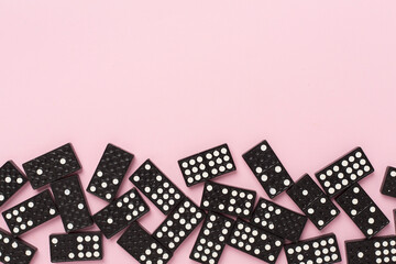Obraz premium Black domino tiles on color background, top view