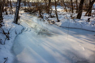 Ice covering a stream and a winter landscape