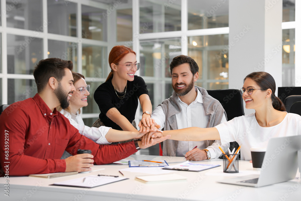 Sticker Team of employees joining hands in office