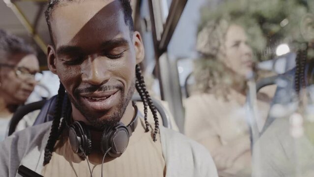Jovem negro, com fones de ouvido, olhando pela janela do onibus. Cinematico 4k.