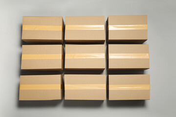 Many closed cardboard boxes with tape on light grey background, flat lay
