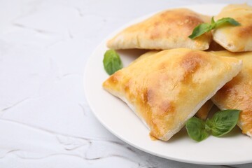 Delicious samosas and basil on white textured table, closeup. Space for text