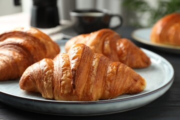 Delicious fresh croissants on dark table indoors, closeup