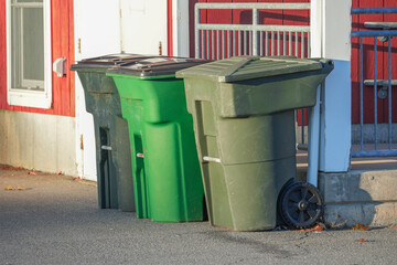 different color garbage bins outside the building