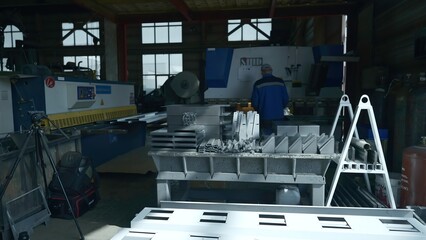 Factory worker with prefabricated metal parts. Creative. Metal parts for assembly of factory...