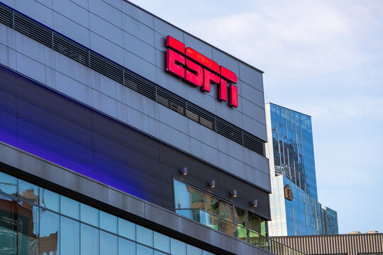The ESPN sign on the side of a building at LA Live with glass skyscrapers and hotels in the city skyline in Los Angeles California USA