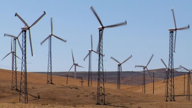 Line of wind turbines working in Altamont Pass wind farm on a sunny day in Northern California, USA